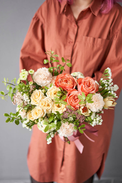 schöner Strauß gemischter Blumen in Frauenhand. Blumenladen-Konzept. schöner frisch geschnittener Strauß. Blumen liefern - Foto, Bild
