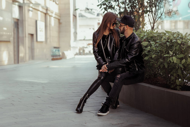Sexy couple posing on a bench and looks at each others in the street - Fotografie, Obrázek