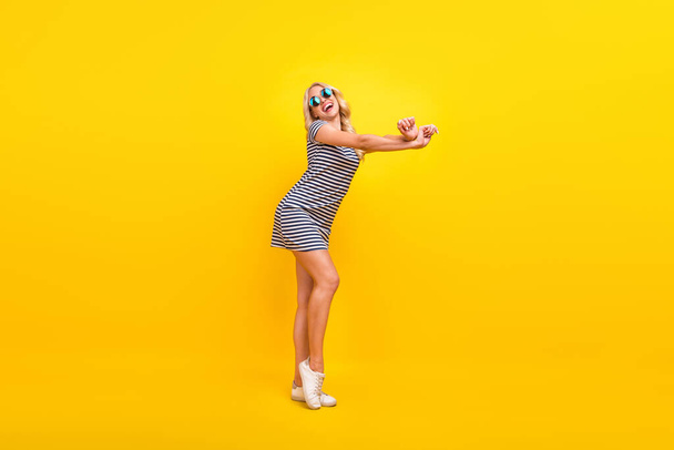 Full length body size photo laughing happy overjoyed woman wearing sunglass dress isolated vibrant yellow color background. - Foto, Imagen