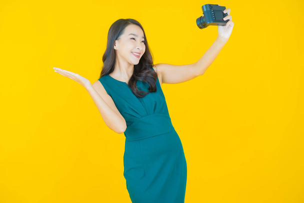 Retrato bonito jovem asiático mulher usar câmera na cor de fundo - Foto, Imagem