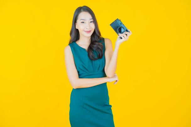 Portrait beautiful young asian woman use camera on color background - Zdjęcie, obraz
