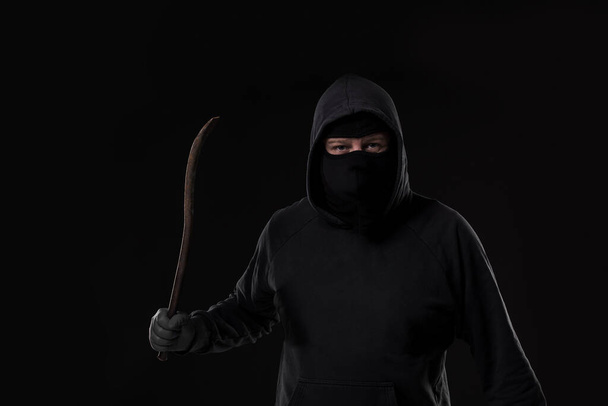 Männlicher Täter maskiert mit einem Fetzen. Auf schwarzem Hintergrund im Atelier - Foto, Bild