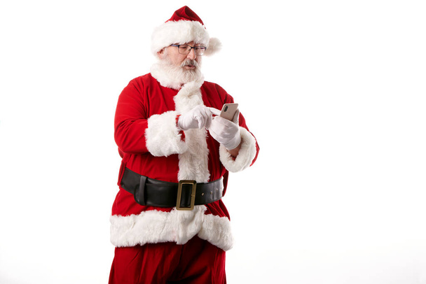 Babbo Natale utilizzando un telefono cellulare su sfondo bianco - Foto, immagini