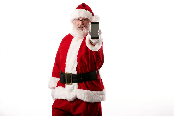 Άγιος Βασίλης χρησιμοποιώντας ένα κινητό τηλέφωνο σε λευκό φόντο - Φωτογραφία, εικόνα