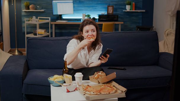 Businesswoman pomocí smartphone při jídle plátek pizzy - Fotografie, Obrázek
