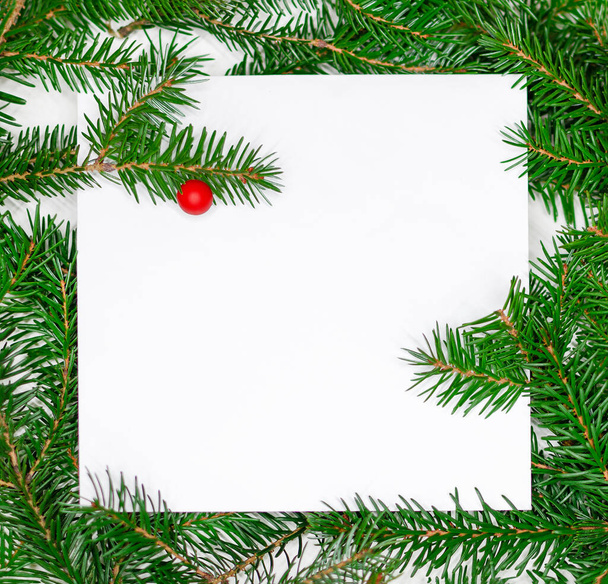La maqueta navideña de las ramas del árbol de Navidad y la tarjeta de papel blanco con el espacio Copiar. Vacaciones, concepto de Navidad - Foto, imagen