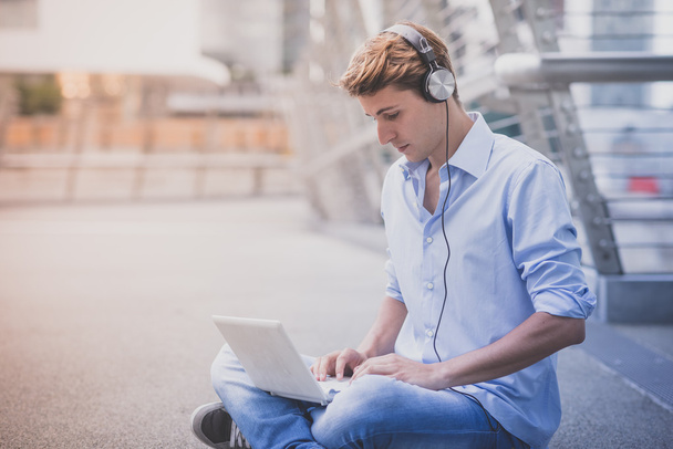 young model hansome blonde man with notebook and headphones - Fotografie, Obrázek