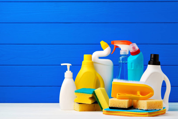 Various cleaning items against blue wooden background - Foto, imagen