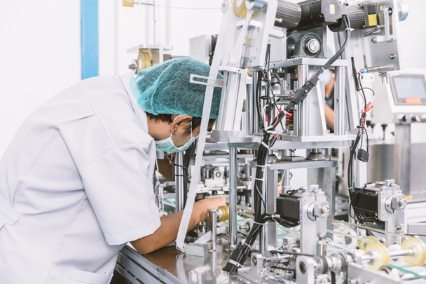 Mühendis, hijyen tıp fabrikasında modern hizmet makinesini tamir ediyor. - Fotoğraf, Görsel