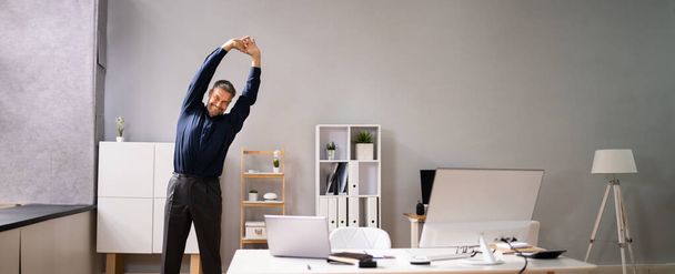 Arms Stretch Exercise Standing Near Desk In Office - Фото, зображення