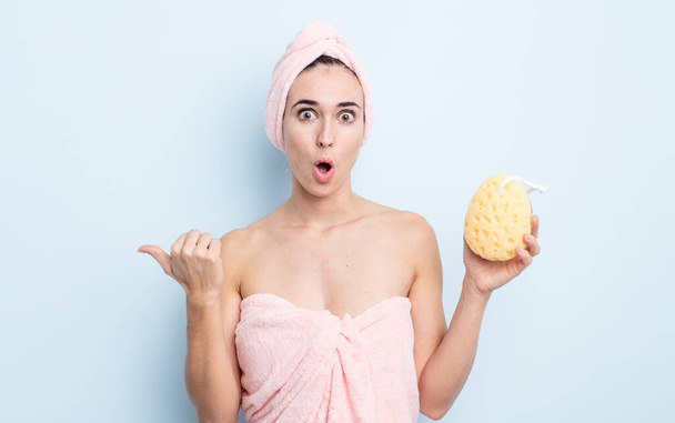young pretty woman looking astonished in disbelief. shower and sponge concept - Foto, imagen