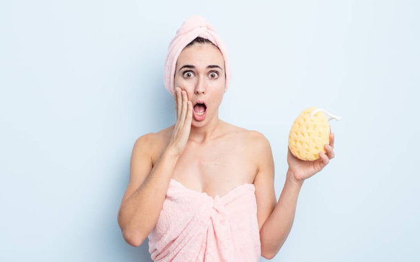 young pretty woman feeling shocked and scared. shower and sponge concept - Foto, Imagem