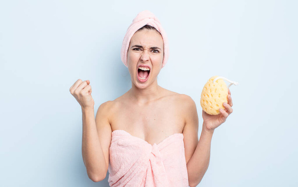 young pretty woman shouting aggressively with an angry expression. shower and sponge concept - Фото, изображение