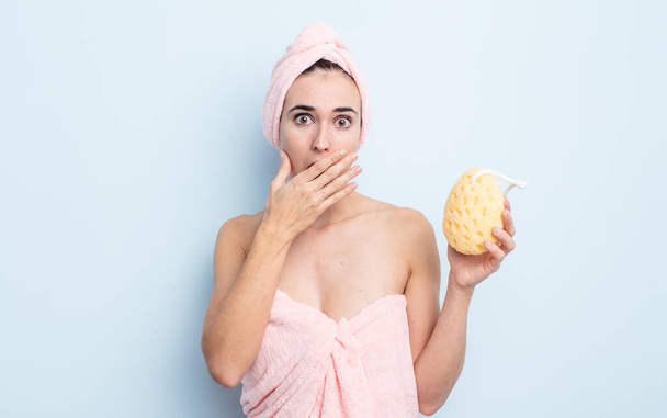young pretty woman covering mouth with hands with a shocked. shower and sponge concept - Foto, Imagem