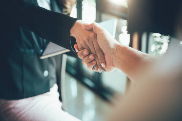 two businessman shake hands as hello in office closeup. Friend welcome, introduction, greet or thanks gesture, product advertisement, partnership approval, strike a bargain on deal concept - Foto, imagen