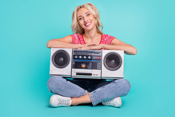 Full body photo of cheerful attractive happy woman sit floor boombox enjoy weekend isolated on teal color background. - Foto, Imagem