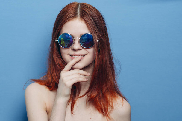 perky red-haired woman in blue glasses bare shoulders posing - Fotoğraf, Görsel