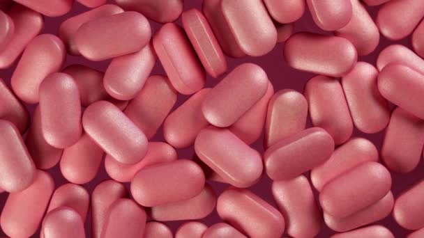 Primo piano vista angolo superiore di mucchio di pillole rosa su una piattaforma a rotazione lenta. Macro dettagliato girato in illuminazione da studio - Filmati, video