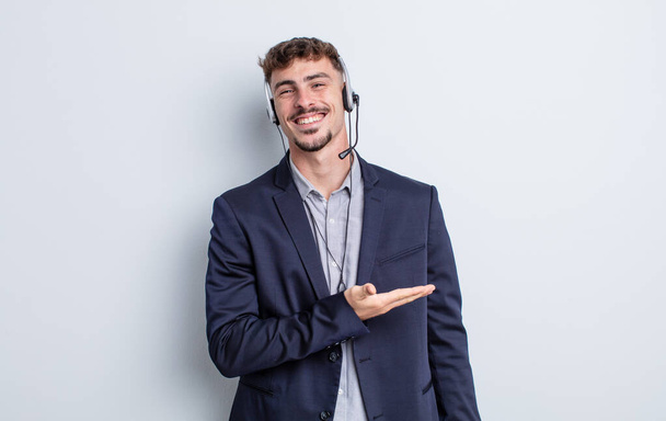 young handsome man smiling cheerfully, feeling happy and showing a concept. telemarketer concept - 写真・画像