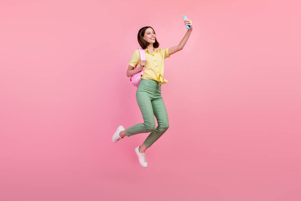 Full body profile side photo of young girl happy smile make selfie smartphone jump isolated over pink color background. - Photo, Image