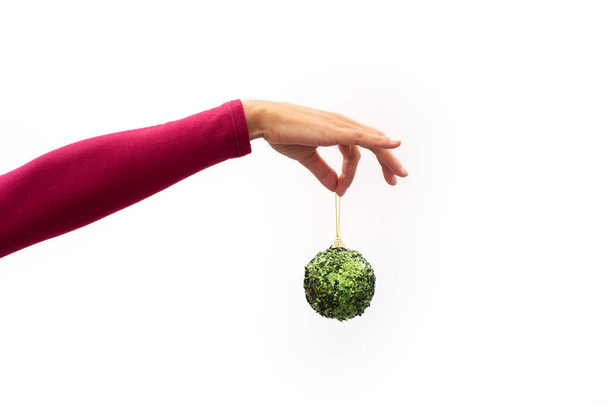 Hand holding a Christmas green ball on white background - Photo, Image