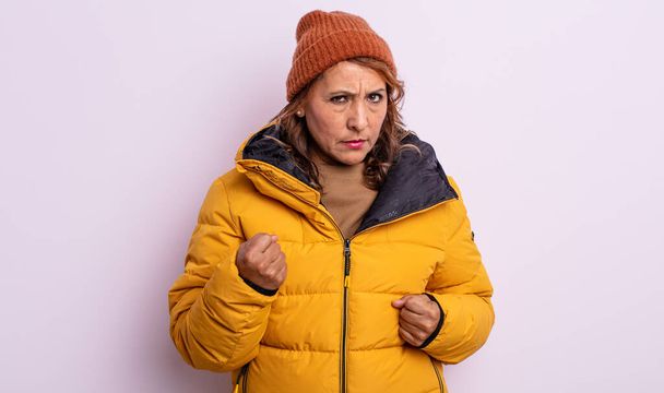pretty middle age woman feeling angry, annoyed, rebellious and aggressive. winter concept - Zdjęcie, obraz