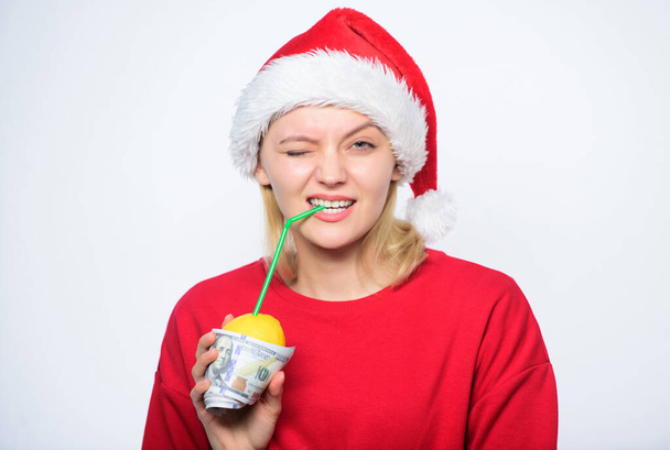 Girl with lemonade and money. Fresh lemonade drink with straw. Symbol of wealth and richness. Christmas lemonade punch. Girl santa hat drink juice lemon wrapped in banknote. Totally natural lemonade - Фото, изображение