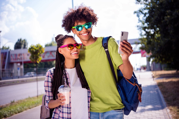 Portrait of attractive cheerful carefree couple spending free time sunny day taking making selfie summertime outdoors - Foto, imagen