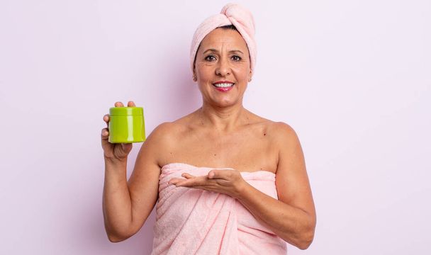 pretty middle age woman smiling cheerfully, feeling happy and showing a concept. shower and hair product concept - Foto, afbeelding