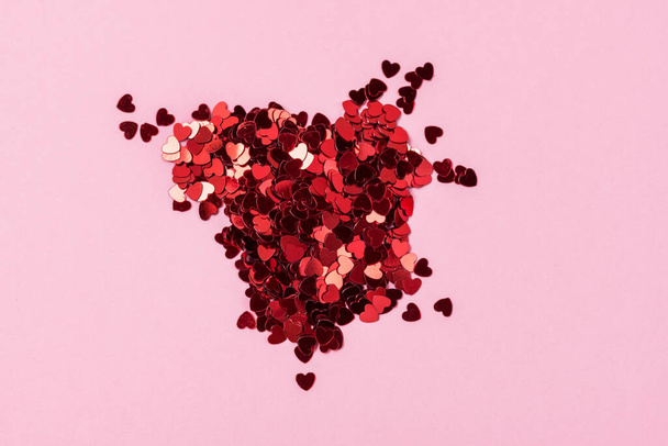 Valentýn pozadí srdce tvarované konfetti na pastelové růžové pozadí horizontální - Fotografie, Obrázek