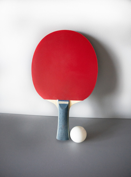 racket en ping pong bal op een grijze achtergrond. - Foto, afbeelding