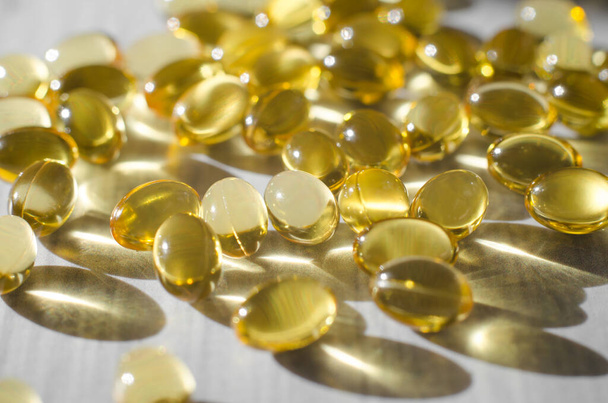 Vitamin-D-3-Kapseln auf einem weißen Holztisch in Großaufnahme - Foto, Bild
