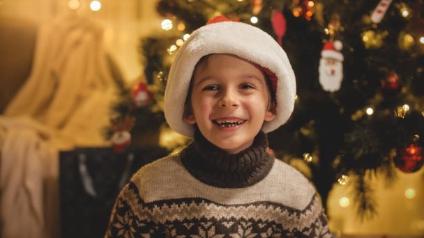 Portret wesołego i uśmiechniętego chłopca świętującego Boże Narodzenie. Rodziny i dzieci świętujące ferie zimowe. - Zdjęcie, obraz