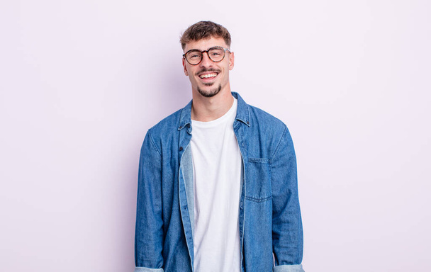 young handsome man with a big, friendly, carefree smile, looking positive, relaxed and happy, chilling - Fotografie, Obrázek