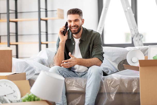 happy man calling on smartphone moving to new home - Foto, Imagem