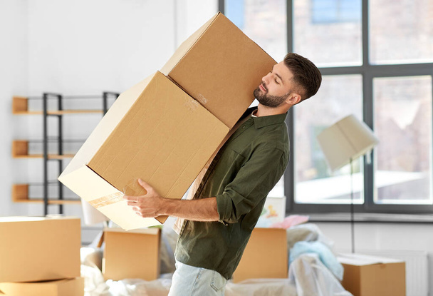 happy man with boxes moving to new home - Φωτογραφία, εικόνα