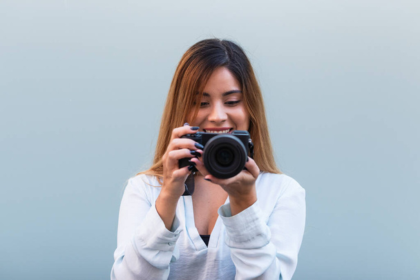 Κοντινό πλάνο της όμορφης μελαχρινής γυναίκας χαμογελώντας, ενώ τη λήψη φωτογραφιών με επαγγελματική κάμερα. Χόμπι έννοια, φόντο με αντίγραφο χώρο για κείμενο - Φωτογραφία, εικόνα
