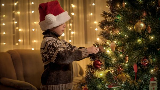 Petit garçon en casquette Santa se préparant pour les vacances et la décoration de l'arbre de Noël. Pures émotions des familles et des enfants qui célèbrent les vacances d'hiver. - Photo, image
