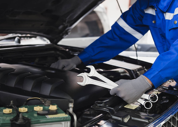 Mechanische werkzaamheden aan de motor van de auto in de garage.Concept van auto-inspectie en auto reparatie. - Foto, afbeelding