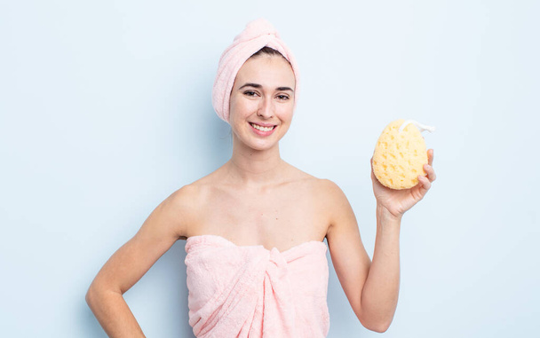 young pretty woman smiling happily with a hand on hip and confident. shower and sponge concept - Photo, image