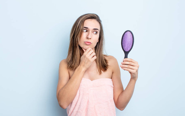 young pretty woman thinking, feeling doubtful and confused. hairbrush concept - Foto, Imagem