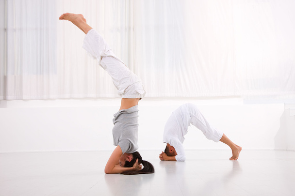 Man and woman practicing yoga in fitness studio - Φωτογραφία, εικόνα