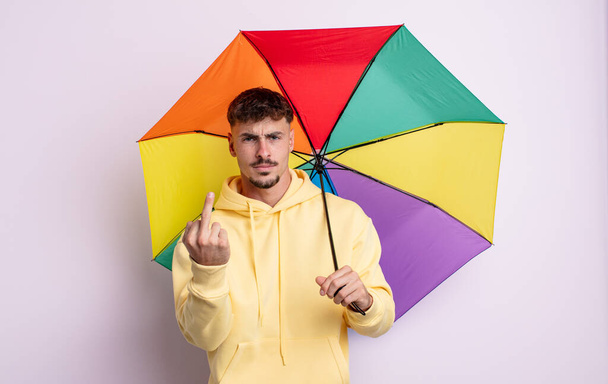 young handsome man feeling angry, annoyed, rebellious and aggressive. umbrella concept - Valokuva, kuva