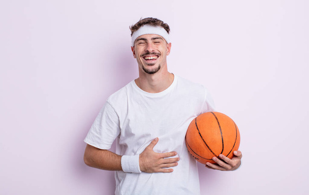 young handsome man laughing out loud at some hilarious joke. basketball concept - Фото, изображение