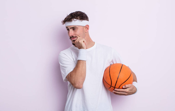 young handsome man smiling with a happy, confident expression with hand on chin. basketball concept - Foto, Imagem