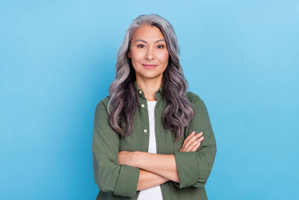 Photo of bossy old grey hairdo lady crossed arms wear khaki shirt isolated on blue color background. - Фото, изображение