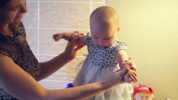 Mom keeps a little baby girl in a dress in her hands - Footage, Video