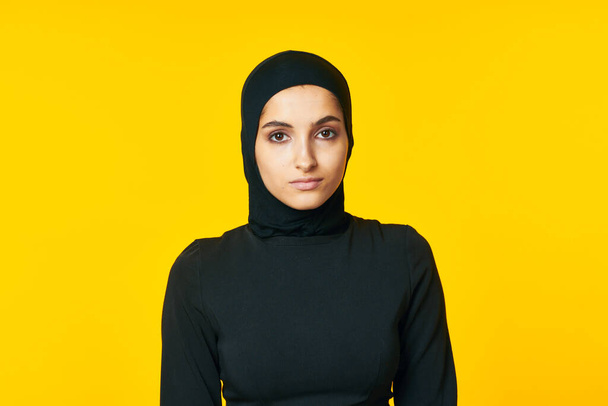 pretty woman muslim black hijab yellow background - Fotó, kép