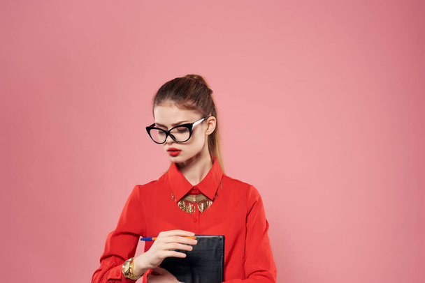женщина в красной рубашке секретарь офиса работать розовый фон - Фото, изображение