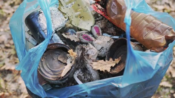 Metal, plastik ve organik atıklarla dolu mavi bir çöp torbasına yakın çekim - Video, Çekim